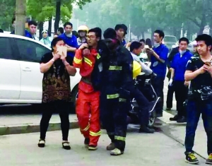 事故現場，受傷的消防隊員被隊友攙扶到一邊休息
